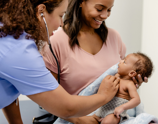 Doctor examining baby with mom